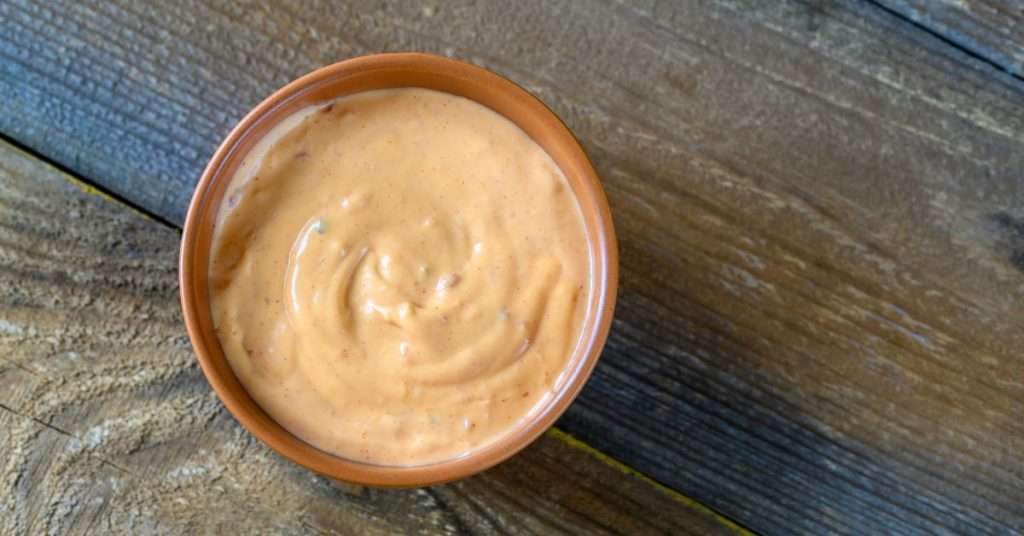 can dogs eat thousand island dressing?  a small ceramic bowl of thousand island dressing on top of a wooden plank.  