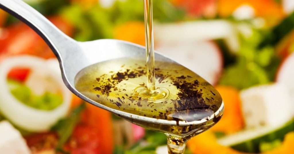 can dogs eat Italian Dressing - Olive oil and spiced being dumped on a spoon, part of some Italian dressing